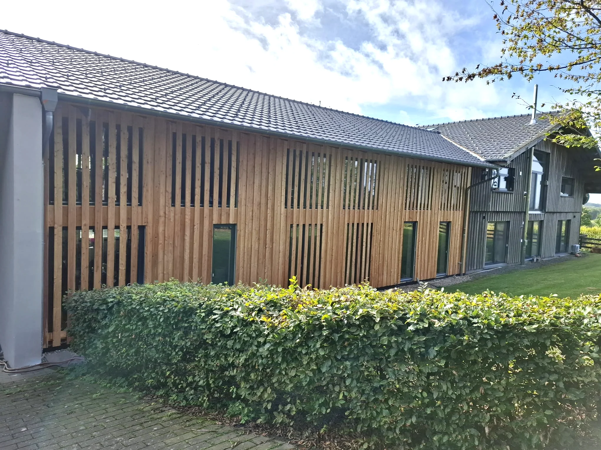 Fertiggestellte Holzfassade mit vertikaler Lärchenschalung – Zimmerei Mathia